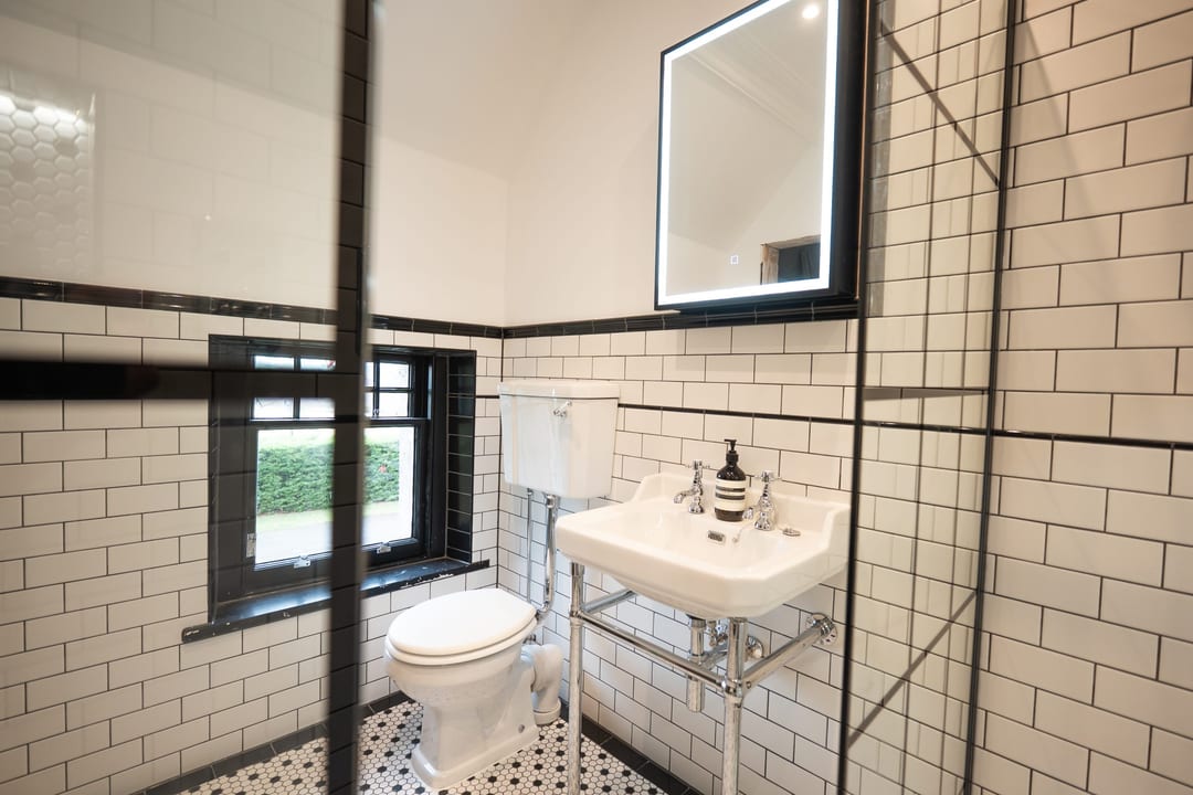Traditional bathroom with herringbone tiling and a white bath