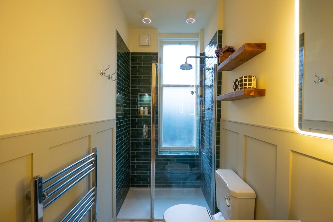 Compact bathroom with a timber vanity, brass fittings and freestanding bath