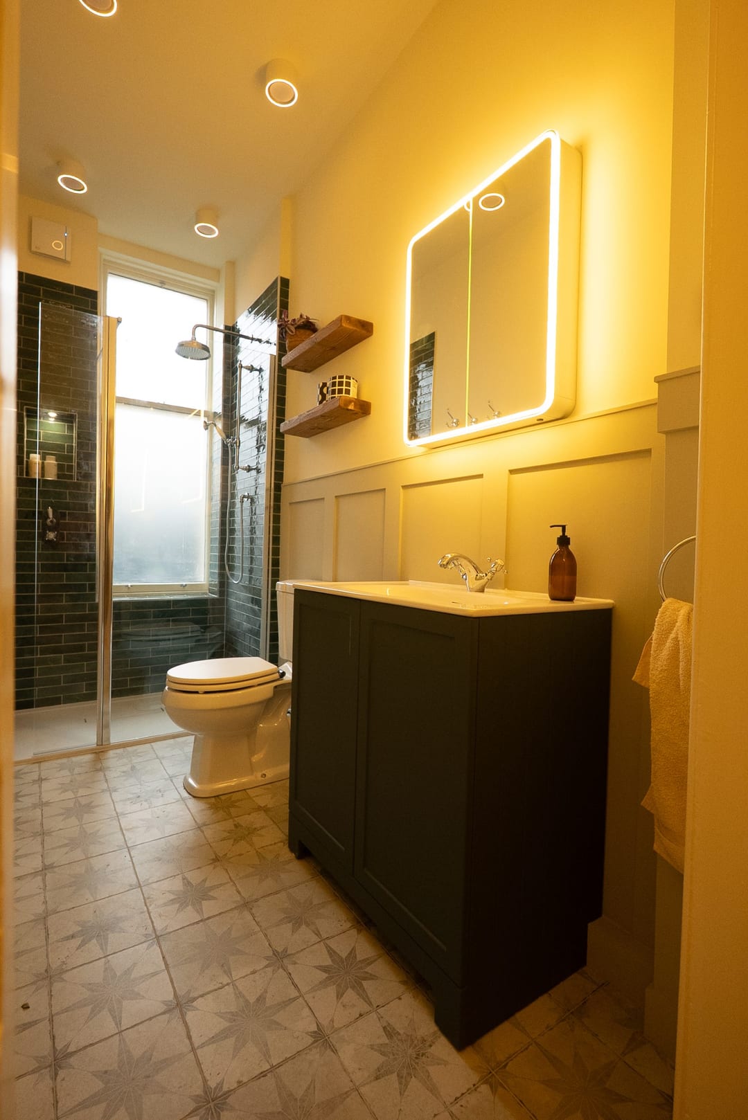 Timber vanity with a white basin and brushed brass tap