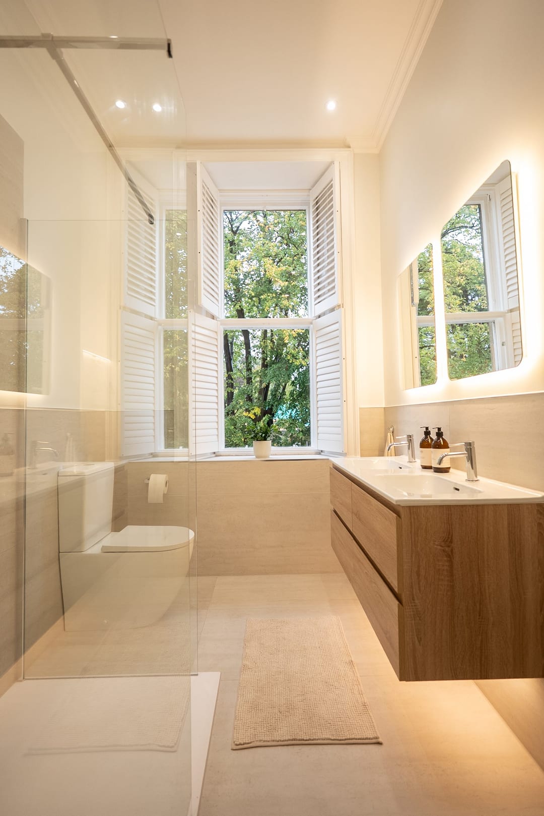 Traditional bathroom with a white bath, oak vanity and large window