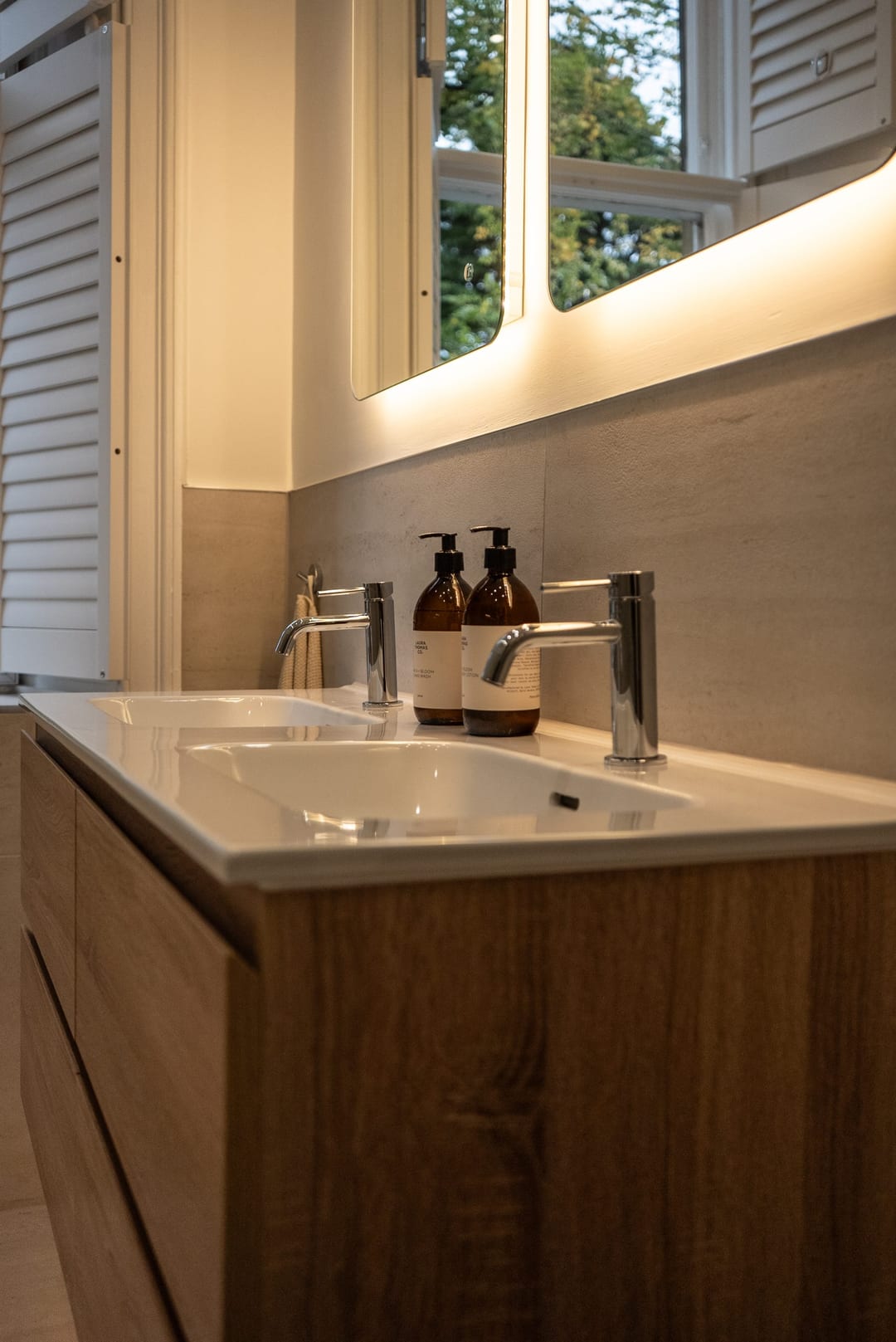 En-suite bathroom with a timber vanity and round mirror