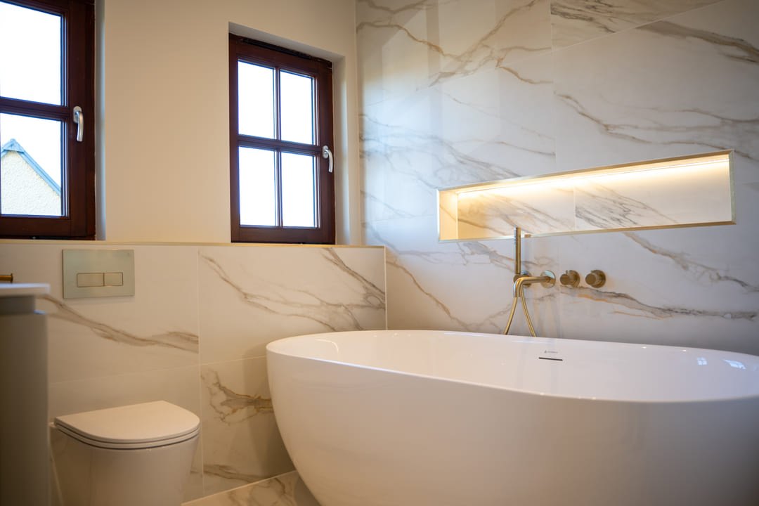 Freestanding bath and wall-hung WC in a marble finished bathroom