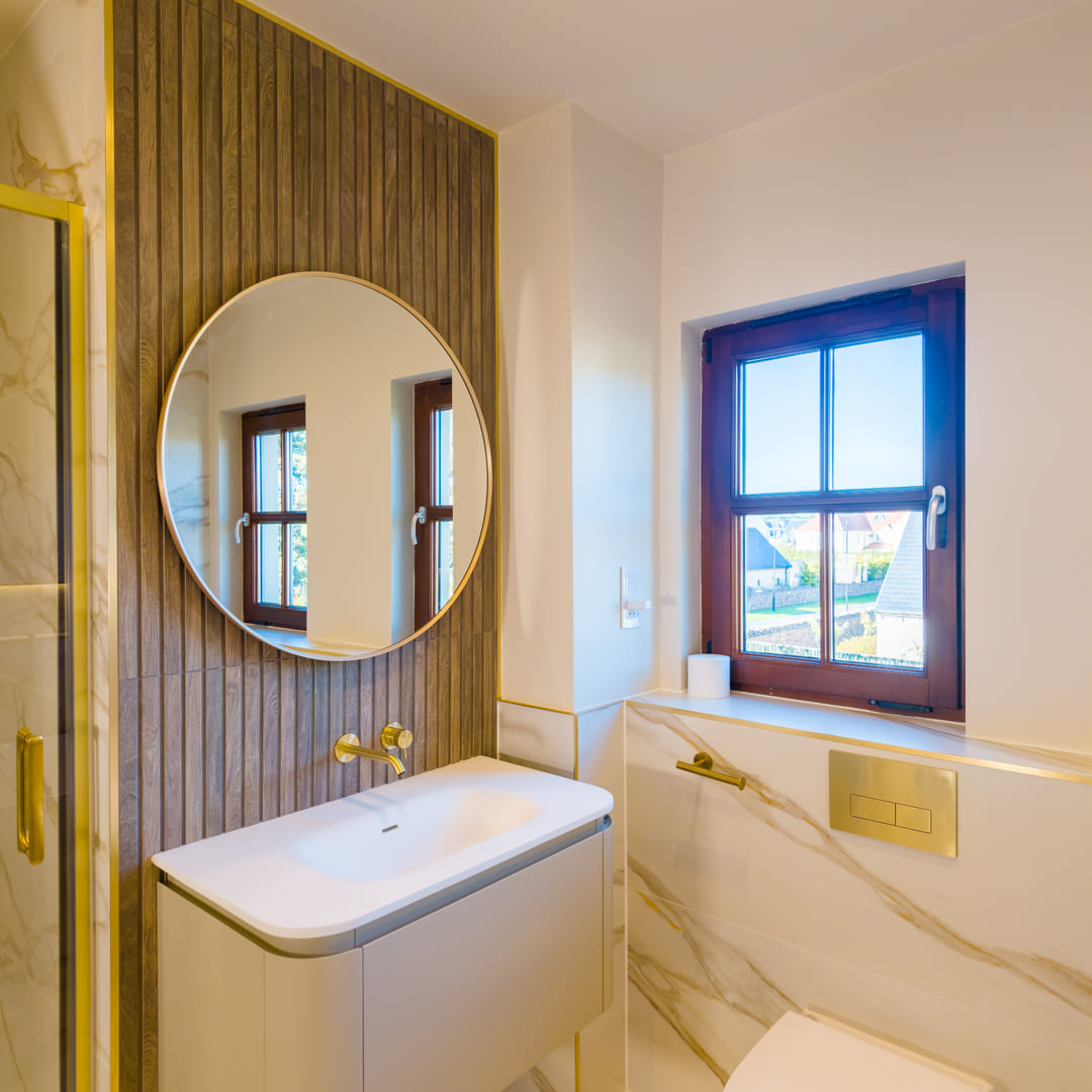 Floating vanity with round brass mirror and fluted wood panelling